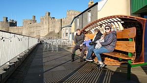 teulu yn eistedd ar Cwch Salmon y GSB1